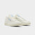 A pair of Reebok men's white sneakers with lace-up closure and a visible blue and white logo on the heel.
