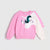 A children's long-sleeve sweatshirt in pink and off-white, featuring a sequined unicorn face graphic on the front and a scalloped pink wing detail on the sleeve, shown against a light gray background.