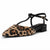 A single women's pointed-toe flat sandal with a black T-strap and ankle buckle, featuring a tan and black leopard-print fuzzy upper, shown on a white background.
