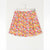 A short pleated skirt with a vibrant multicolor floral print, hanging on a white hanger against a plain white wall.