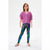 A young girl modeling shiny, iridescent leggings with a purple cardigan and pink shoes, standing against a plain white studio background.