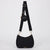 Black woven crescent shoulder bag with an adjustable black strap, a small round black coin pouch, and gold-tone hardware, shown on a light gray background.