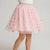 A pink tulle tutu skirt with metallic rose gold bow patterns, shown on a model from the waist down against a light gray background.