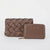 A brown woven leather clutch bag with a matching zip-around wallet, both featuring gold-tone 'bebe' branding, displayed on a clean white background.