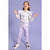 A young girl smiling and posing in a white long-sleeve sweatshirt with a colorful dinosaur print, paired with light purple jogger pants and white sneakers, set against a solid lavender studio background.