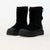 A pair of black mid-calf boots with thick lug soles and a textured toe cap, shown on a plain white studio background.