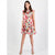 A woman modeling a sleeveless tiered mini dress with a vibrant multicolor floral print, set against a plain light gray studio background.