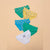 Four pairs of women's briefs arranged on a warm beige background: one green pair with a black-and-white soccer ball pattern, one yellow pair with a floral print, one blue pair with a soccer ball pattern, one solid green pair, and one light gray pair with a small circular logo.