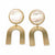 A pair of gold-tone drop earrings featuring a round, iridescent mother-of-pearl disc at the top and a wide, open U-shaped gold-tone metal piece hanging below, set against a plain white background.