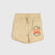 Beige children's shorts featuring a drawstring waist and a graphic print of Lightning McQueen from Disney's Cars on the left leg, displayed against a light gray background.