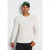 A man wearing a cream-colored long-sleeve henley shirt, dark jeans, and a green baseball cap with a white letter 'A' on the front, standing against a light gray background.