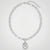 A silver-toned paperclip chain necklace with an oval pendant featuring a starburst motif, displayed on a clean white background.