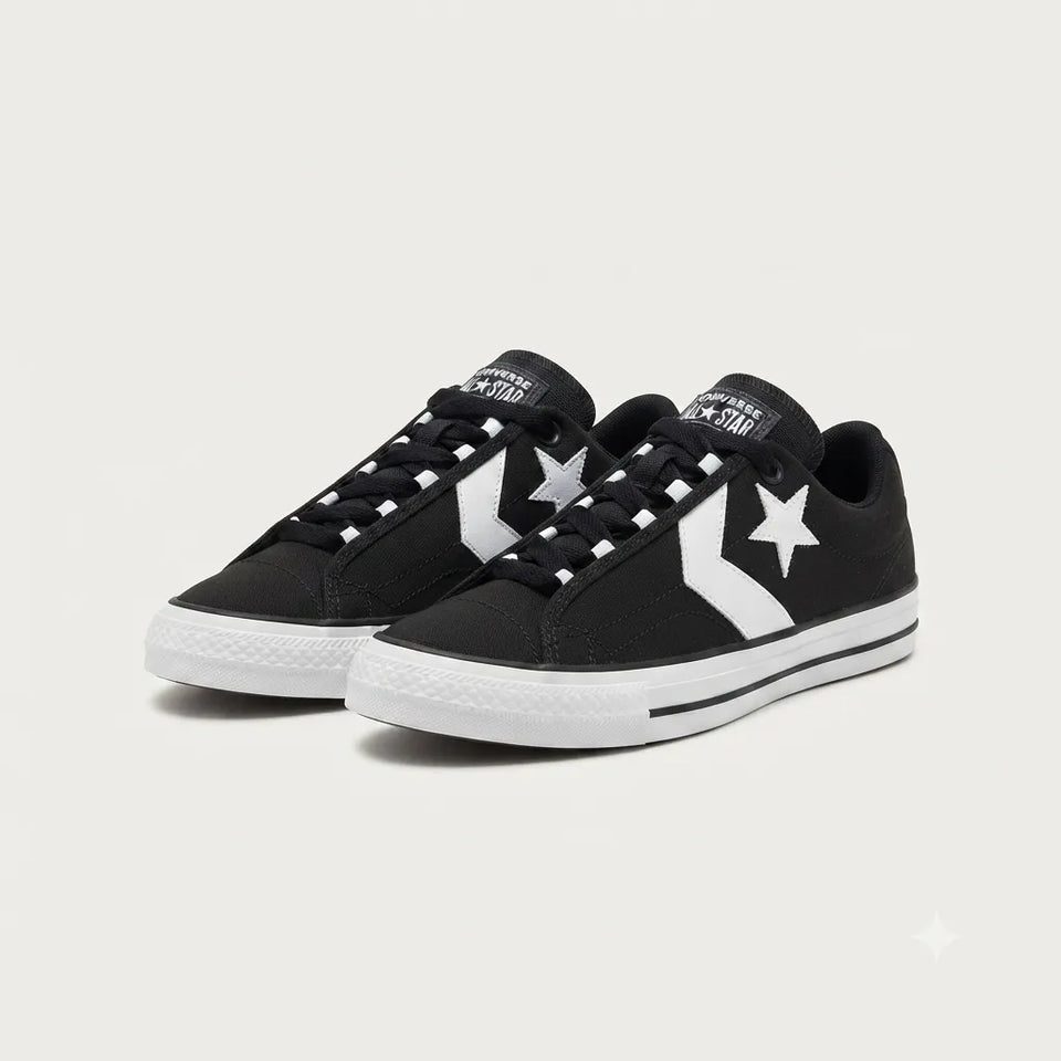 A pair of black low-top sneakers with white star logos and white soles, photographed on a clean light gray background.