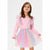 A young girl wearing a pink long-sleeve dress with a pastel rainbow tulle tutu skirt and matching ruffled shoulder details, photographed against a plain light gray studio background.