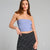 A woman modeling a light blue strapless tube top paired with a black and white polka dot skirt, photographed against a solid light gray studio background.