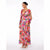 A woman modeling a long-sleeve maxi dress with a vibrant multicolor floral print, featuring a wrap-style V-neck bodice and pleated skirt, set against a plain white studio background.