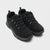 A pair of black low-top lace-up shoes with textured laces, silver eyelets, and thick black soles, photographed on a light gray background.