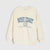 An off-white crewneck sweatshirt featuring a blue 'WEST COAST' graphic with a circular emblem and small text printed on the chest, displayed against a light gray background.