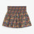 A smocked elastic waist mini skirt with a dense multicolor floral print on a dark olive green background, featuring yellow, blue, red, and pink flowers.