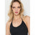 A blonde woman wearing a black halter-neck tank top and layered silver necklaces, shown from the chest up against a light gray studio background.