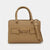 A structured tan leather handbag with top handles, a matching shoulder strap, and a decorative front strap featuring a prominent oval logo clasp that reads 'bebe'.