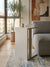 Modern living room with a gray sofa, white side table, and abstract art on the wall.