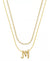 Two gold necklaces on a white background: a longer chain necklace and a shorter chain necklace with a script letter 'M' pendant.