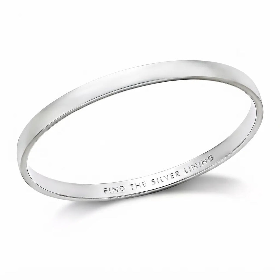 A polished silver bangle bracelet with the engraved text 'FIND THE SILVER LINING' visible on the inside, shown on a clean white background.