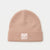 A dusty pink knit beanie hat with a folded cuff and a small square patch featuring a fox illustration and the text 'MY PUPPIE'.