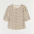 A short-sleeve button-up blouse with a beige and brown leopard print pattern, laid flat against a light off-white background.