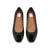 A pair of black patent leather ballet flats with a glossy finish and a small bow detail on the toe, shown from a top-down view on a white background. The interior lining is tan with a visible 'dv shoes inc.