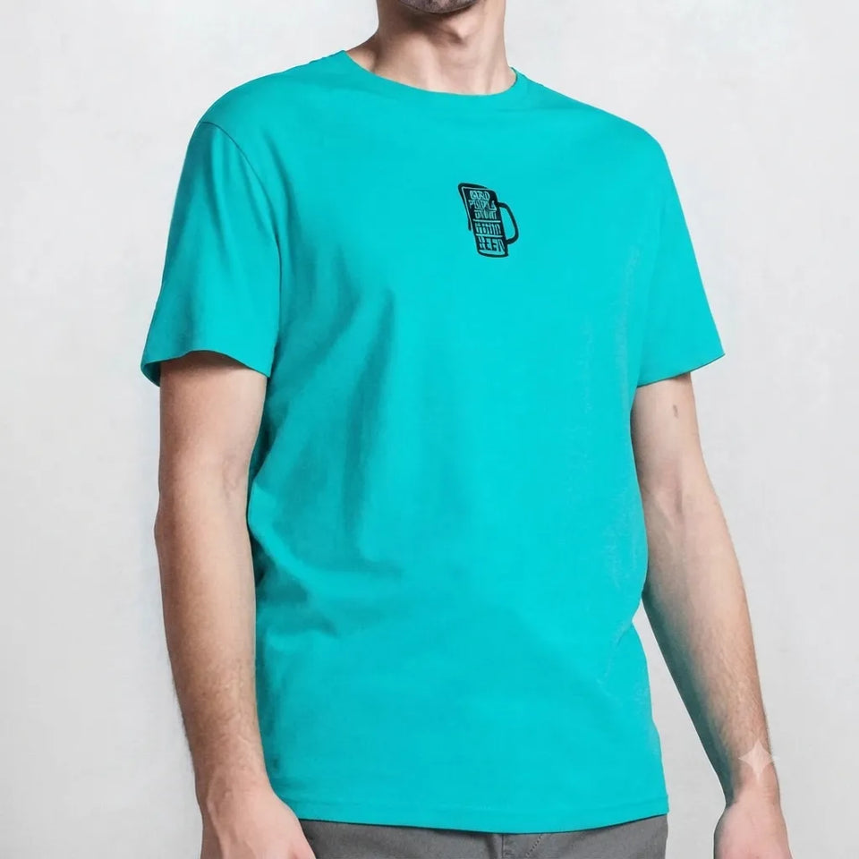 A man wearing a bright turquoise crewneck t-shirt with a small black graphic of a mug on the left chest, shown against a light gray background.
