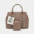 A beige and brown monogram handbag set by bebe, featuring a structured handbag with a matching zippered wallet in front, both with protective plastic wrapping on the handles and attached retail tags.