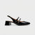 Gray suede platform shoe with a decorative strap on a white background