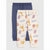 Two pairs of children's jogger pants laid flat on a light gray background. The front pair is cream with a colorful safari animal print including giraffes, lions, zebras, crocodiles, and airplanes.