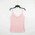 A light pink spaghetti-strap camisole top with a small white polka dot pattern, hanging on a black hanger against a plain white background.