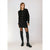 A model wearing a black ribbed cardigan with gold buttons, a black textured mini skirt, sheer black tights, and black leather over-the-knee boots, standing against a light gray studio background.