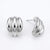 A pair of polished silver-tone stud earrings with a ribbed, rounded design, shown on a clean white background with one earring facing forward and the other showing the side profile and post.