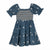 A toddler's blue smocked dress with puff sleeves and white floral embroidery, shown against a plain white background.
