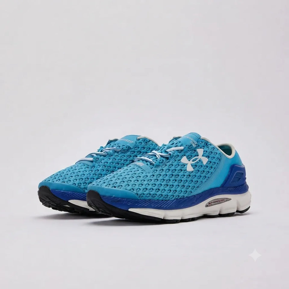 A pair of Under Armour athletic sneakers in bright blue and navy with white accents, shown on a light gray studio background.