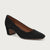 A single black suede pump with a low block heel and pointed toe, shown from a side profile on a light gray background.