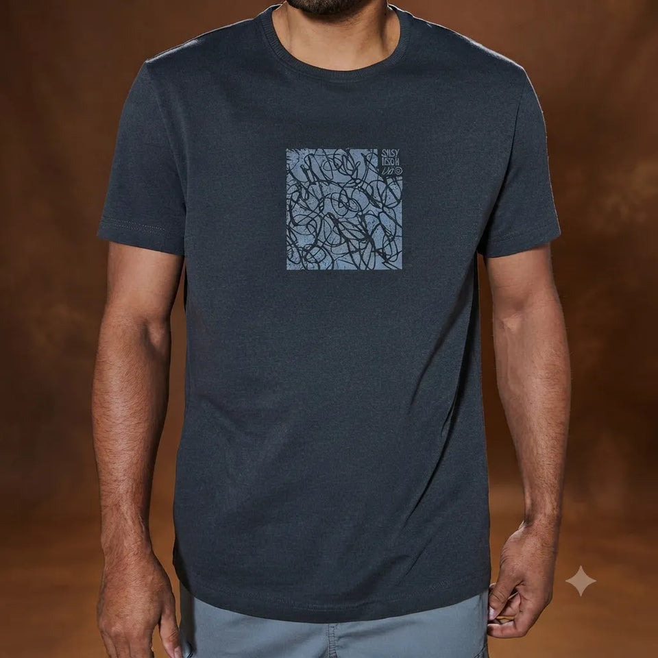 A man wearing a dark navy blue crewneck t-shirt with a square graphic print on the chest featuring a blue and black abstract pattern and the text 'BOY TOY STUDIO'.