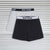 Two pairs of boxer briefs laid flat on a white slatted background: one light gray and one black, both with elastic waistbands printed with the brand name NEW LEAGUE.