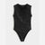 A sleeveless black bodysuit covered in shimmering sequins, featuring a draped neckline and a scoop neck, laid flat against a light gray background.