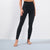 A model wearing black high-waisted leggings, shown from the waist down against a clean light gray studio background.