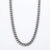 A silver-toned metal chain necklace with a curb link design, photographed against a clean white background.