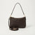 A dark brown pebbled leather shoulder bag with a top zipper, gold-tone hardware, and a detachable long strap, displayed on a light gray background.