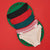Four pairs of women's bikini-style underwear arranged in a fan shape on a green circular mat with a red background. The colors are black, red, teal, white with red pattern, and beige with white pattern.