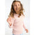 A young girl with curly brown hair wearing a light pink and white horizontally striped long-sleeve shirt, smiling and looking upwards against a plain white background.