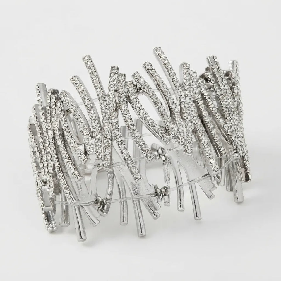 A wide silver-toned cuff bracelet embellished with multiple rows of clear rhinestones, photographed on a clean white background.